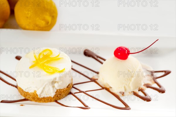 Very elegant lemon mousse dessert served whith lemon peel on top and vanilla ice cream on side