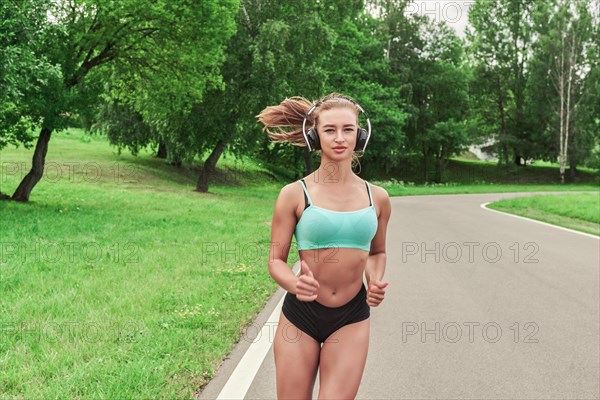 Sports girl jogging in the park. The concept of a healthy lifestyle. Sports Equipment. Fitness style advertisement. Mixed media