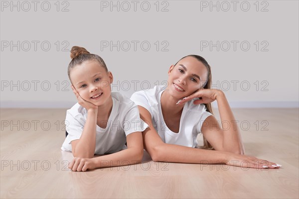 Beautiful female teacher poses with a little girl in a gymnastics class. The concept of education