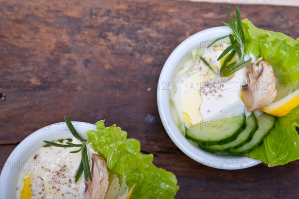 Fresh organic garlic cheese dip salad on a rustic table