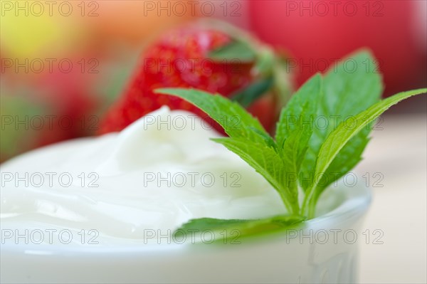 Organic Greek yogurt and strawberry over white rustic wood table