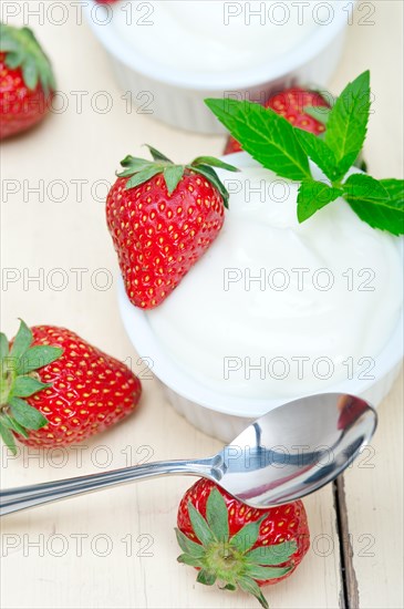 Organic Greek yogurt and strawberry over white rustic wood table