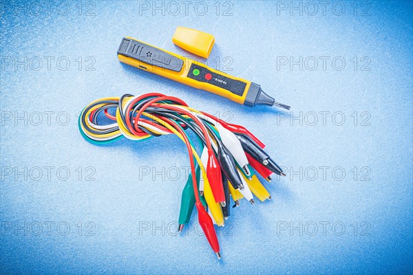 Electrical tester indicator crocodile plugs on blue background electricity concept
