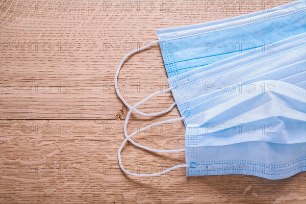 Blue disposable face masks on wooden board medical concept