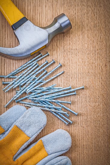 Composition of claw hammer nails and protective glove on wooden boards