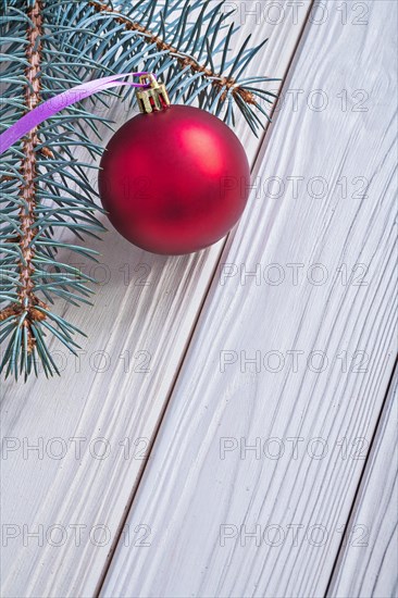 Copyspace picture mat red Christmas bauble and Christmas tree branch on white wooden panels