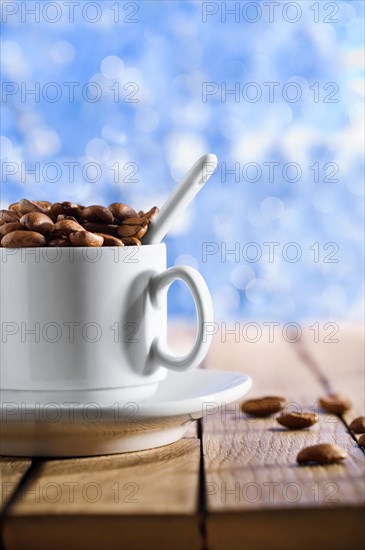 Cup with coffee beans on the wooden table