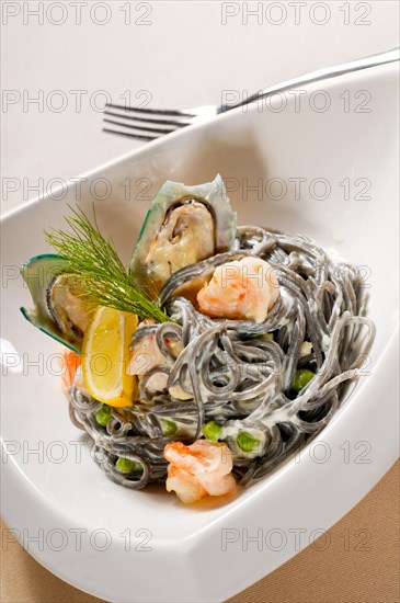 Fresh seafood black squid ink coulored spaghetti pasta tipycal italian food