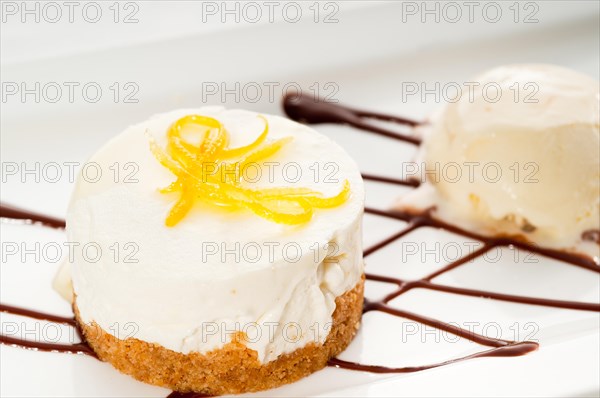 Very elegant lemon mousse dessert served whith lemon peel on top and vanilla ice cream on side