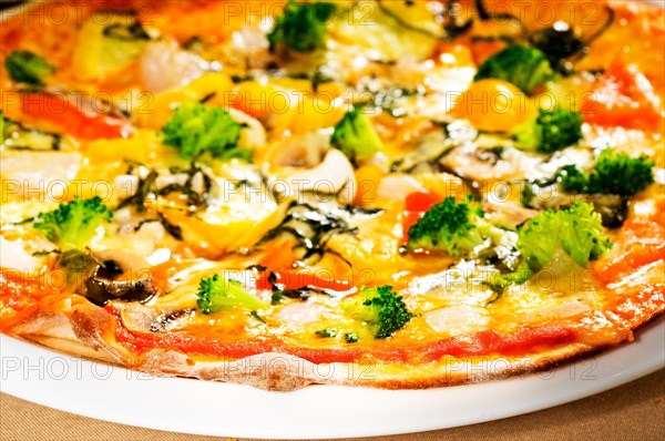 Fresh italian thin style vegetarian pizza with fresh mixed vegetables close up