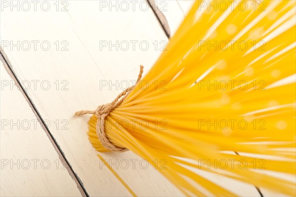 Italian pasta spaghetti tied with a rope on a rustic table