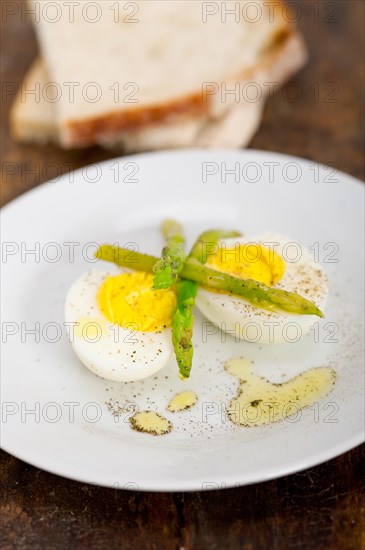 Boiled fresh green asparagus and eggs with extra virgin olive oil with rustic bread