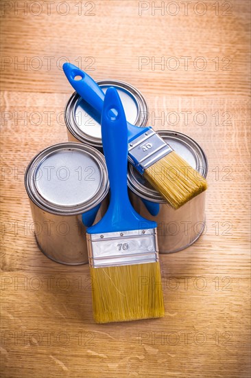 Composition of two brushes and three tins on a wooden board