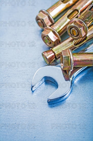 Metal anchor bolts for concrete walls and spanners on a metallic background Construction concept