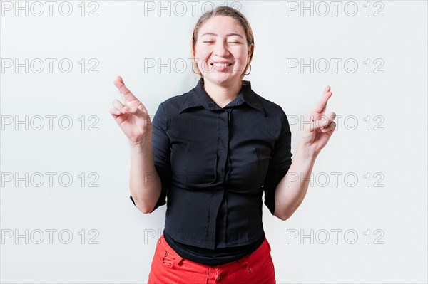 Smiling hopeful girl making a wish with her fingers isolated. Beautiful smiling girl crossing fingers making a wish