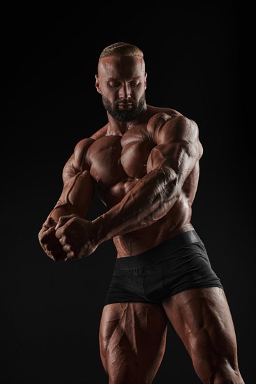 Handsome strong athletic men pumping up muscles. Workout