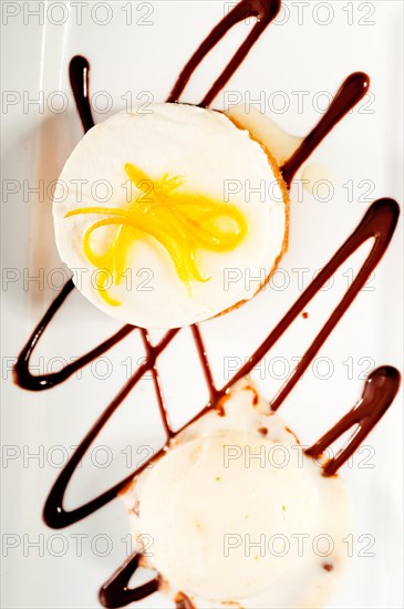 Very elegant lemon mousse dessert served whith lemon peel on top and vanilla ice cream on side