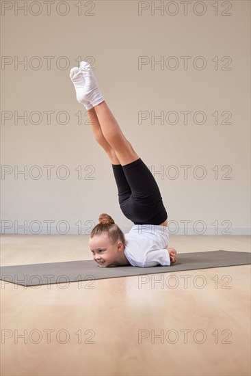 Little girl performs exercises in a gymnastics sports class. The concept of sports