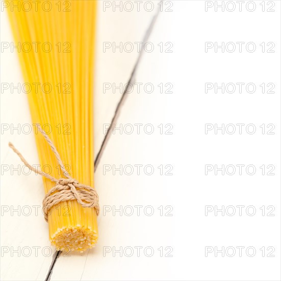 Italian pasta spaghetti tied with a rope on a rustic table