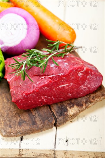 Fresh raw beef cut ready to cook with vegetables and herbs