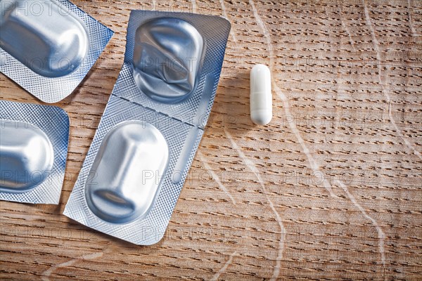 Blister pack with pills on wooden board medical concept