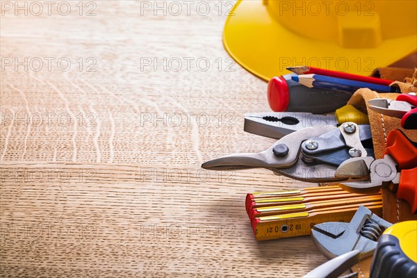 Organised copy room Hammer Tape measure Wrench Pliers Cutter Pencil in tool belt on wooden board