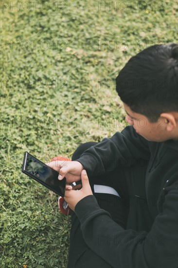 Top view young millennial boy sitting in the park