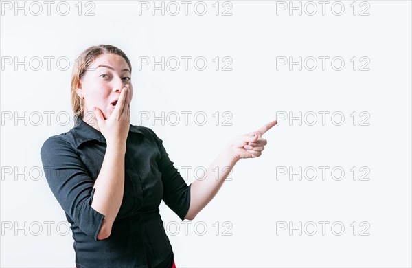 Surprised young woman pointing an advertising isolated. Beautiful woman pointing to a banner to the side. Funny people pointing a promo isolated