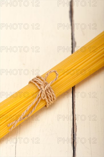 Italian pasta spaghetti tied with a rope on a rustic table