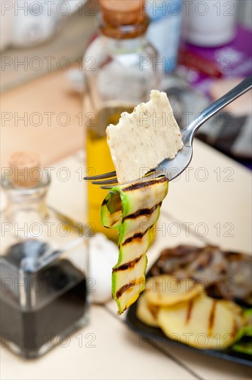 Grilled zucchini courgette on a fork with cracker macro close up