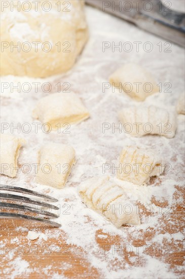 Making fresh Italian potato gnocchi on a wood rustic table