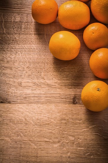Fresh ripe orange fruits on vintage wooden board with organised copyspace