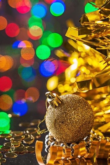 Gold Christmas bauble on the background of dark bokeh