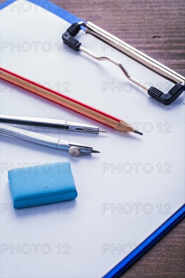 Pencil Eraser Compass and clipboard with paper on vintage wooden board Learning concept