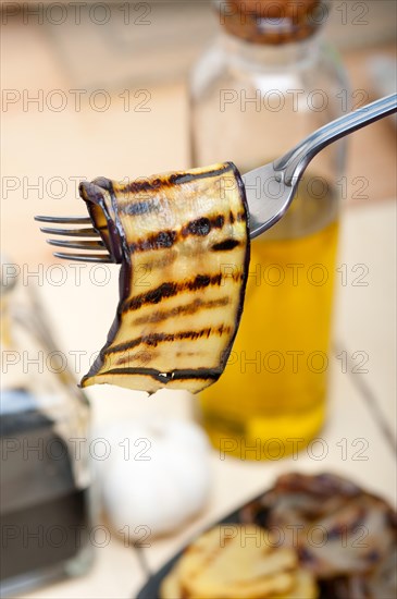 Grilled eggplant oubergine on a fork macro close up