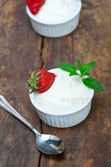 Organic Greek yogurt and strawberry on a rustic wood table