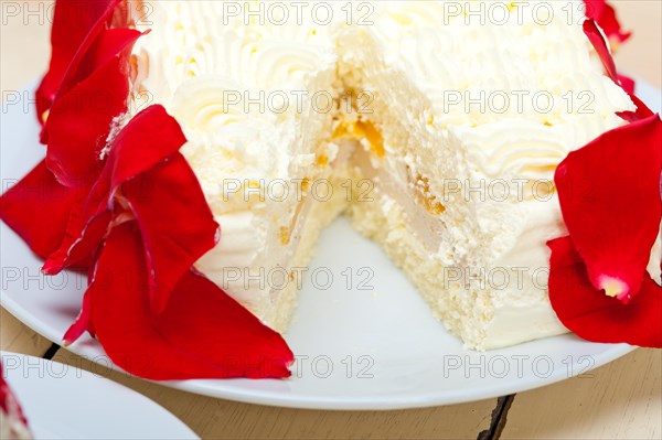 Whipped cream mango cake with red rose petals