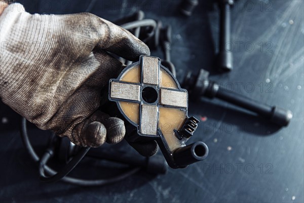 Engine ignition coil in hand of auto mechanic