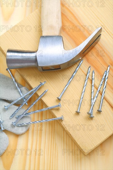 Composition of hammer and nails with glove in close-up