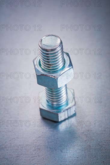 Metallic background with threaded bolt and construction nut Repair concept