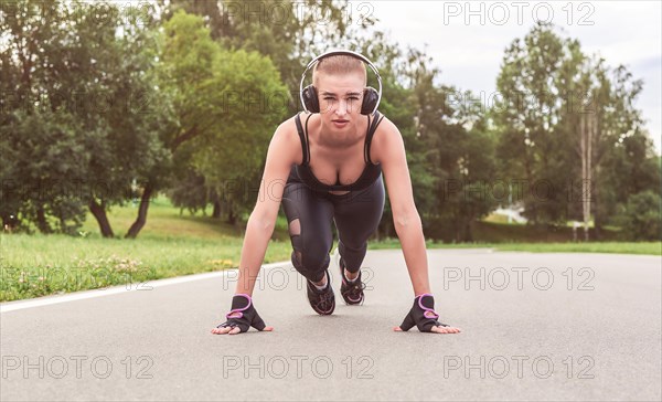 Image of a girl in headphones who stands in a lower position before starting to run. The concept of a healthy lifestyle. Mixed media