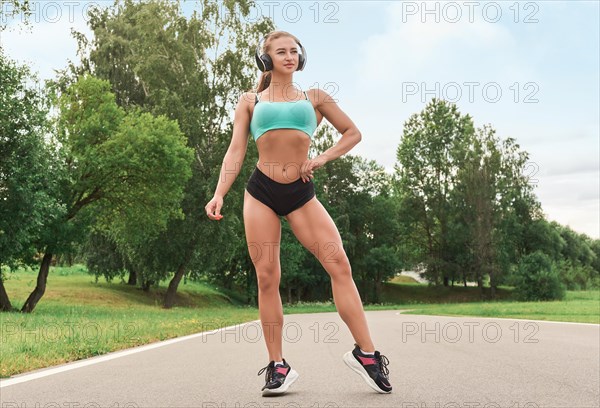 Charming girl does a workout in the park. The concept of a healthy lifestyle. Sports Equipment. Fitness style advertisement. Mixed media