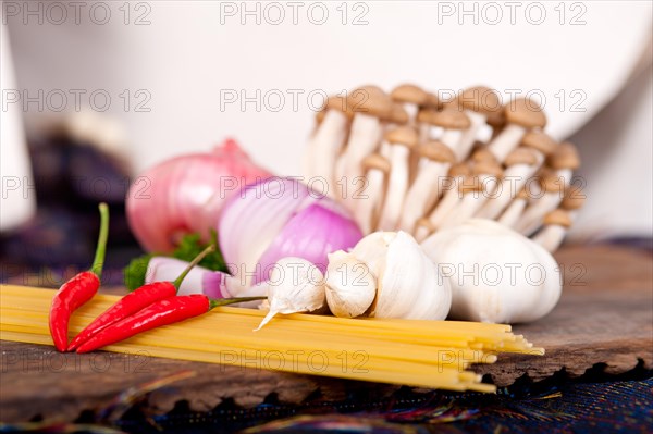 Italian pasta and mushroom sauce raw ingredients over rustic old wood