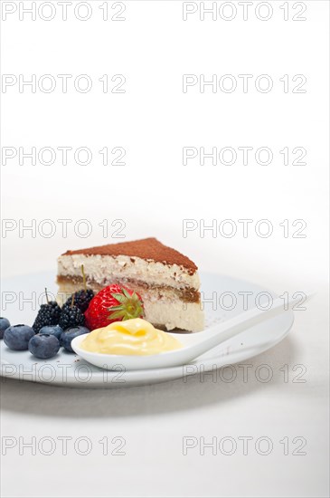 Classic Italian tiramisu dessert with berries and custartd pastry cream on side