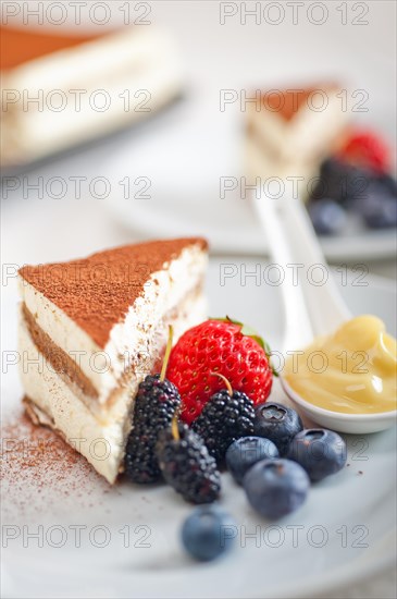 Classic Italian tiramisu dessert with berries and custartd pastry cream on side