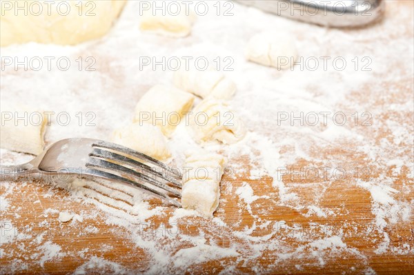 Making fresh Italian potato gnocchi on a wood rustic table