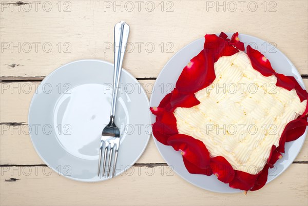 Whipped cream mango cake with red rose petals