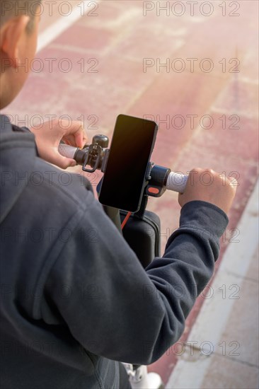 Young man riding an electric scooter outdoors