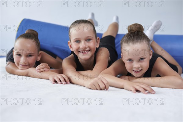 Image of a group of little girls in the gym after a workout. Gymnastics concept. Mixed media