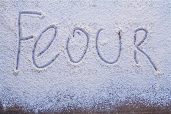 Inscription of hands on flour with dark wood surface Advertising sign